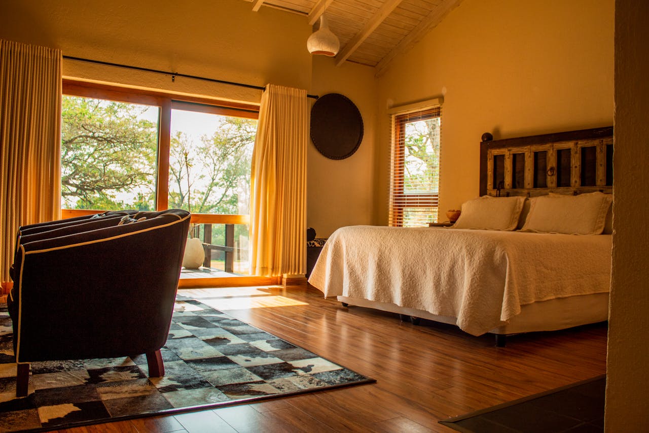 Warm and inviting rustic bedroom with a scenic view in a South African lodge.